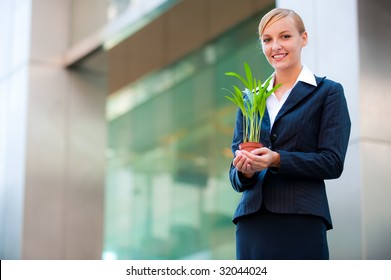 A Beautiful Woman Holding A Plant To Signify Business Growth