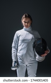 Beautiful Woman Holding Rapier And Fencing Mask Isolated On Black