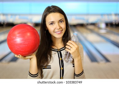 Beautiful Woman Holds Red Ball And Bottle With Water In Bowling Club; Shallow Depth Of Field