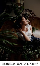 Beautiful Woman With A Lot Of House Plants At Home.