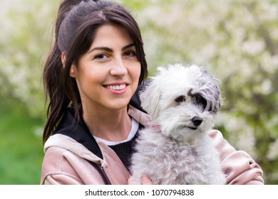Beautiful Woman Hugging  Her Cute Dog in the Spring park.Pet and Owner Outdoor