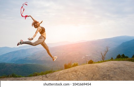 Beautiful woman jumper on High mountain. at sunrise. - Shutterstock ID 1041669454
