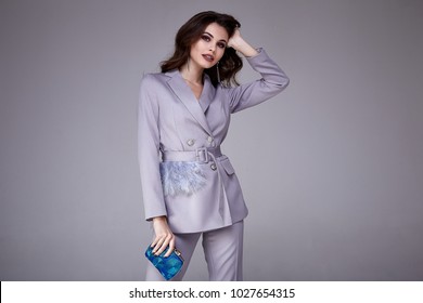Beautiful woman lady spring autumn collection glamor model business office fashion clothes wear formal dress code style lilac color suit jacket pants accessory bag pretty face hair background studio.