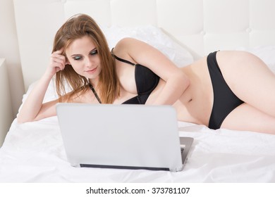 Beautiful Woman With A Laptop On The Bed