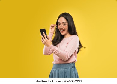 beautiful woman laughing looking at the screen of a smartphone