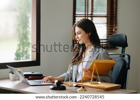 Beautiful woman lawyer working and gavel, tablet, laptop in front, Advice justice and law concept.
