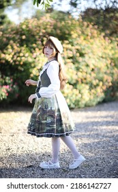 A Beautiful Woman In Lolita Dress In Garden Background Japanese Street Fashion Portrait