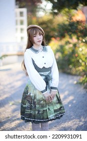 A Beautiful Woman In Lolita Dress In Garden Background Japanese Street Fashion Portrait