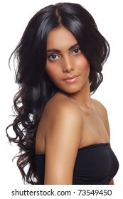 beautiful woman with long black curly hair, tanned skin and natural make-up over white background.