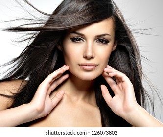 Beautiful woman with long brown hair. Closeup portrait of a fashion model posing at studio.