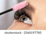 Beautiful Woman with long eyelashes in a beauty salon. Eyelash extension procedure. Lashes close up