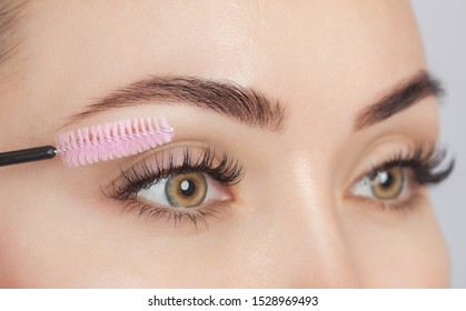 Beautiful Woman with long eyelashes in a beauty salon. Eyelash extension procedure. Cosmetology skin care