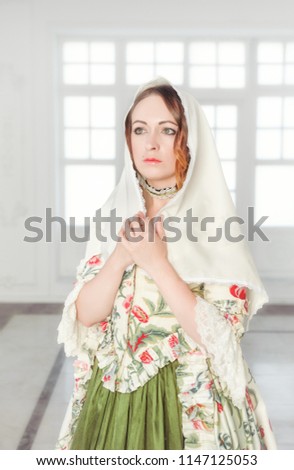 Beautiful woman in long green medieval dress with shawl