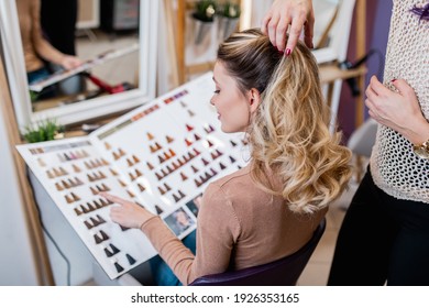 Beautiful woman with long hair at the beauty salon choosing hair color and hairstyle. Hair salon styling concept.