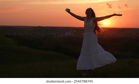 Beautiful woman with long hair spinning in dance on meadow enjoying freedom. Woman in white dress dancing spinning with raised hands, sunset in park in summer. Happy emotions of girl, outdoor party - Powered by Shutterstock