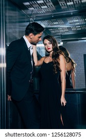 Beautiful Woman Looking At Camera Man And Touching Man Face In Elevator