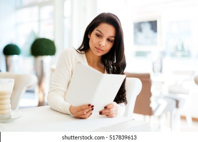 Beautiful Woman Looking At Menu In Restaurant