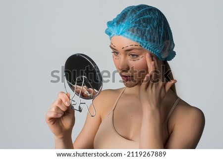 Beautiful Woman looking in the mirror before Plastic Surgery Operation Cosmetology. Beauty Face