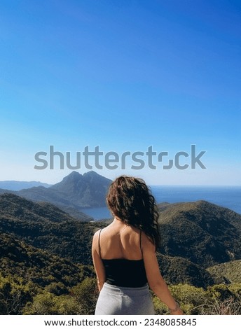 Beautiful woman looking at the mountains of Corsica, France. High quality photo