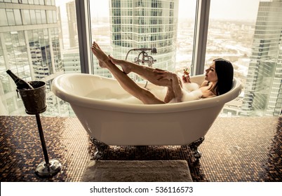 Beautiful Woman Looking Outside The Window In Her Beautiful Apartment