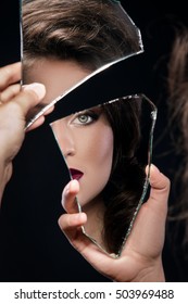 Beautiful Woman Looking In The Piece Of Mirror