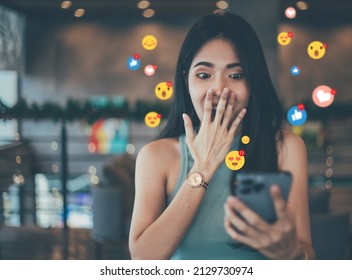 A beautiful woman looks at her smartphone in amazement against 
When receiving emoji and emoticon reactions on her mobile smart device while posting. Social media ideas and marketing sharing or video 
