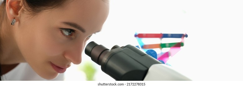 Beautiful Woman Looks Through A Microscope, Profile View