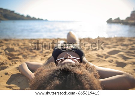 Beautiful woman lying down at the beach and looking the horizon