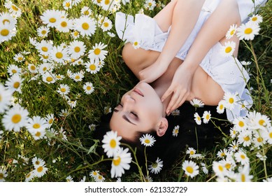 Beautiful Woman Lying Down In Daisy Field