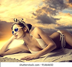 Beautiful woman lying on the sand and tanning - Powered by Shutterstock