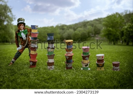 Beautiful woman as mad hatter with hats in nature