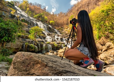 Beautiful woman make photo Mae Ya Waterfall is one of the most beautiful cascades in Doi Inthanon national park, Chiang Mai.