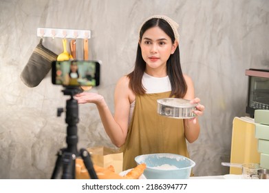 A Beautiful Woman Is Making Bakery While Live Streaming Or Recording Video On Social Media In Her House, Coffee Shop Business Concept. 