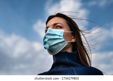 The beautiful woman in medical mask standing outdoor