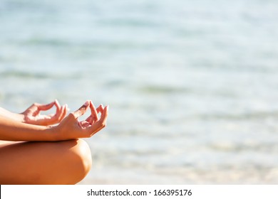 Beautiful woman meditating at the beach.Copy space - Powered by Shutterstock
