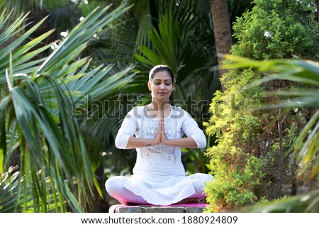 Beautiful woman meditating at park