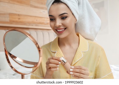 Beautiful Woman With Mirror Applying Makeup In Bedroom