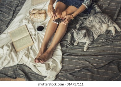 Beautiful Woman Model With Coffee, Pastries, Home Phone On The Blanket With A Cat