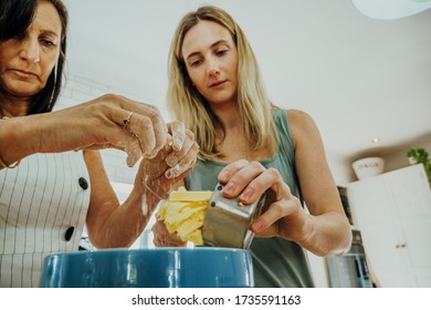 Beautiful Woman And Mother Baking Together In Kitchen At Home