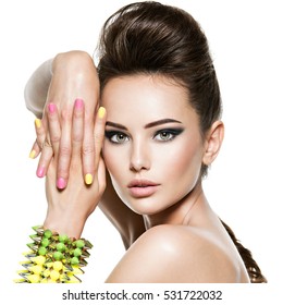 Beautiful  woman with multicolored nails and studded bracelet on hand