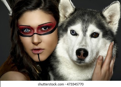 Beautiful Woman In Native American Costume Posing In A Studio With Hasky Dog