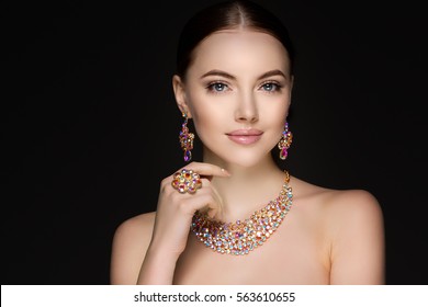 Beautiful woman in a necklace, earrings and ring. Model in jewelry from precious stones, diamonds.