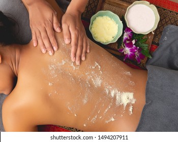 Beautiful Woman Njoying A Salt Scrub Massage And Having Exfoliation Treatment In Spa Room. Brunette Getting A Salt Scrub Beauty Treatment In The Health Spa. Body Scrub.