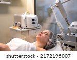 Beautiful woman on ozone therapy with facial steamer in beauty salon.