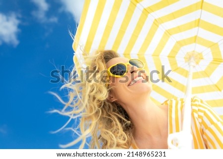 Beautiful woman on summer vacation. Low angle view portrait of happy person against blue sky background. 