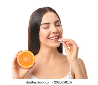 Beautiful Woman With Orange Taking Vitamin C Pill On White Background