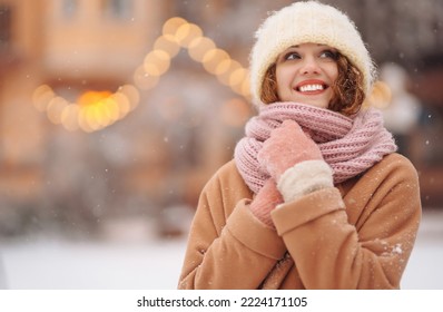 Beautiful woman outdoor during christmas time in front of christmas lights. Holidays, rest, travel concept.