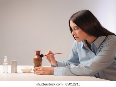 Beautiful Woman Painting A Ceramic Vase