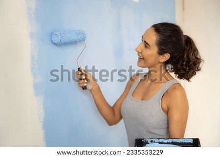 Beautiful woman painting home with smiling. Home renovation DIY renew home concept. 