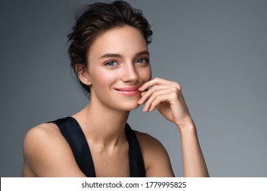 Schöne Frau mit perfektem Make-up auf grauem Hintergrund. Beauty- und Hautpflegekonzept